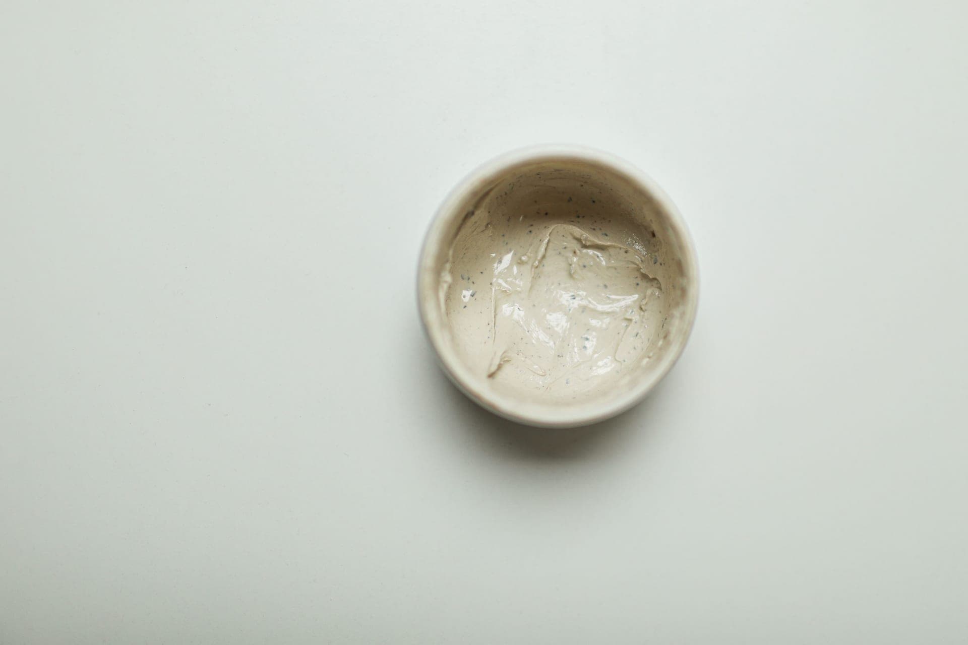 A swatch of white moisturizer on a soft neutral background